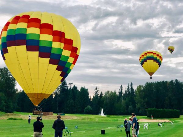 This picture is of 3 Hot air balloons coming in for landing in Woodinville