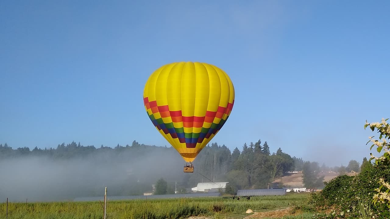 hot air balloon floating over lake